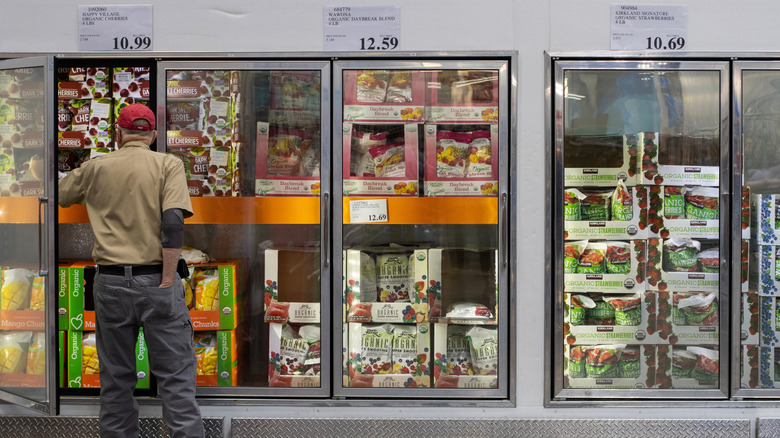 man shopping frozen foods in grocery store
