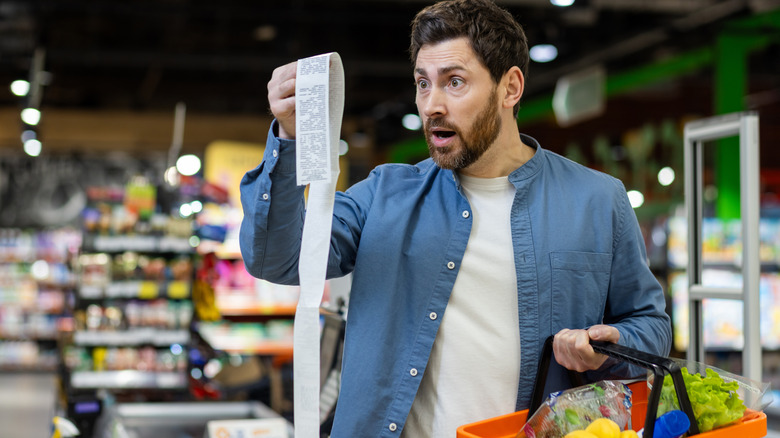 Amazed buyer doing grocery shopping and getting surprised by prices.