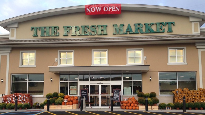 A Now Open sign hanging in front of The Fresh Market entrance