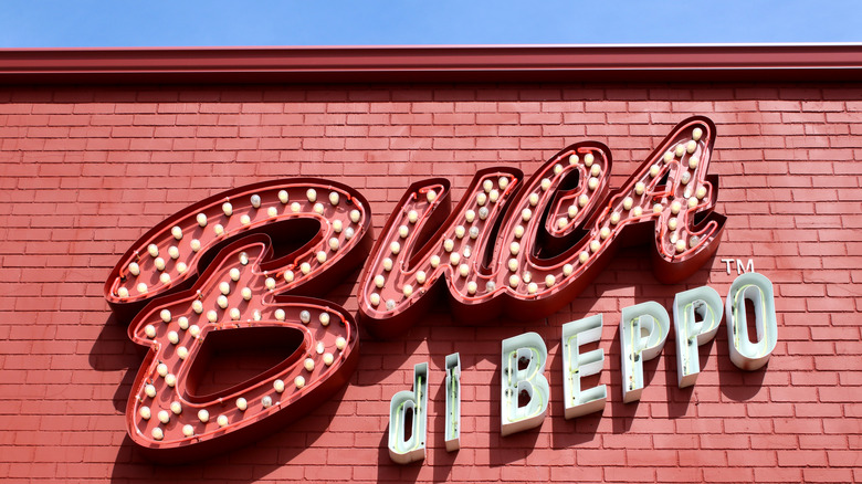 Exterior photo of a Buca di Beppo sign from a restaurant. The sign is placed upon a red brick building.