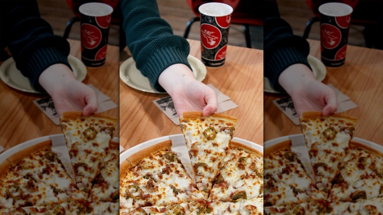 Hand grabbing slice of pizza