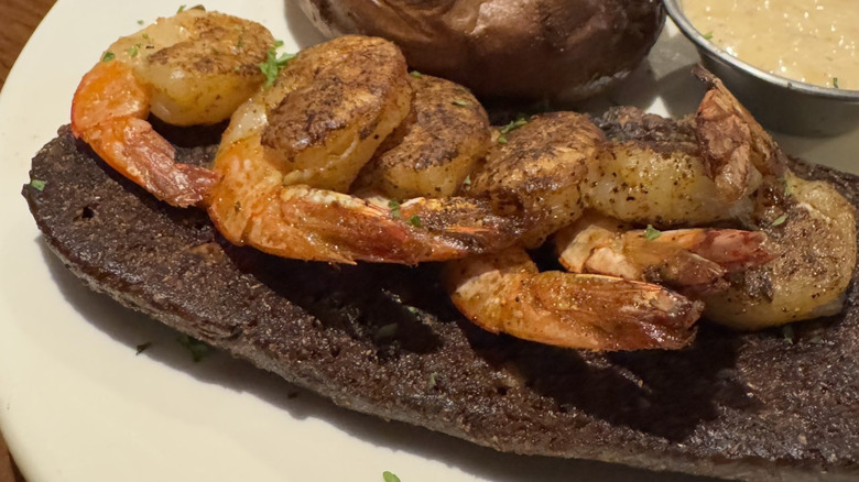 An order of grilled shrimp served on a piece of toast.