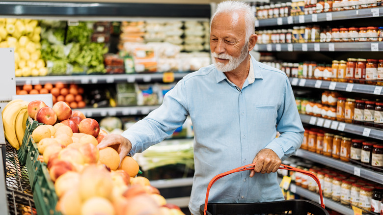 An older man shopping for fresh produce at a grocery store