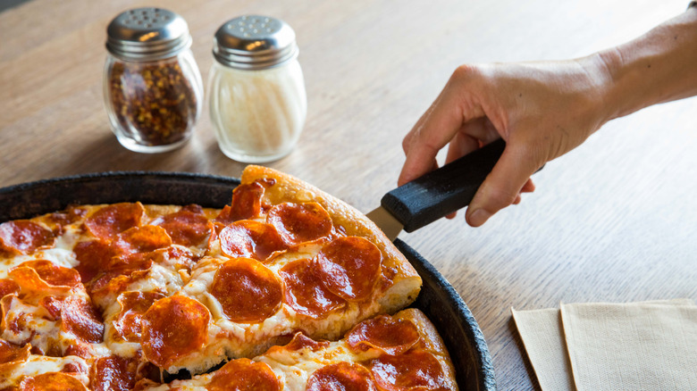 Getting a slice of pepperoni pizza