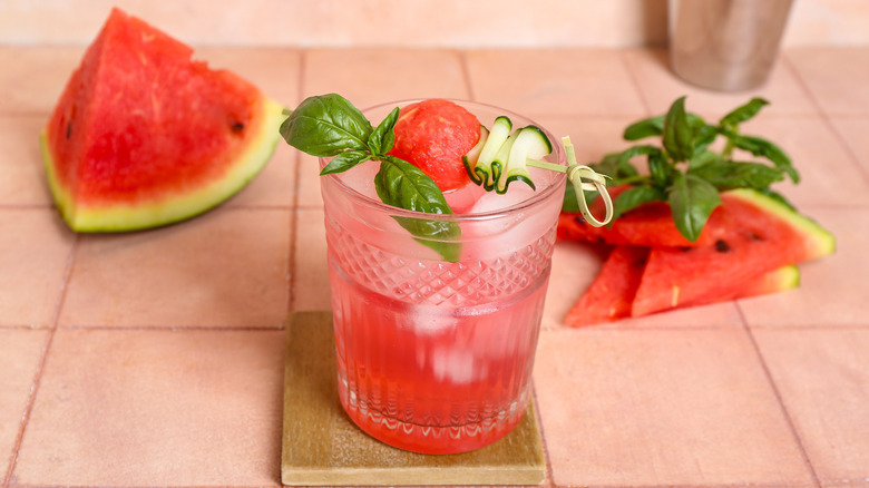 Watermelon cocktail with fresh basil and cucumber garnish