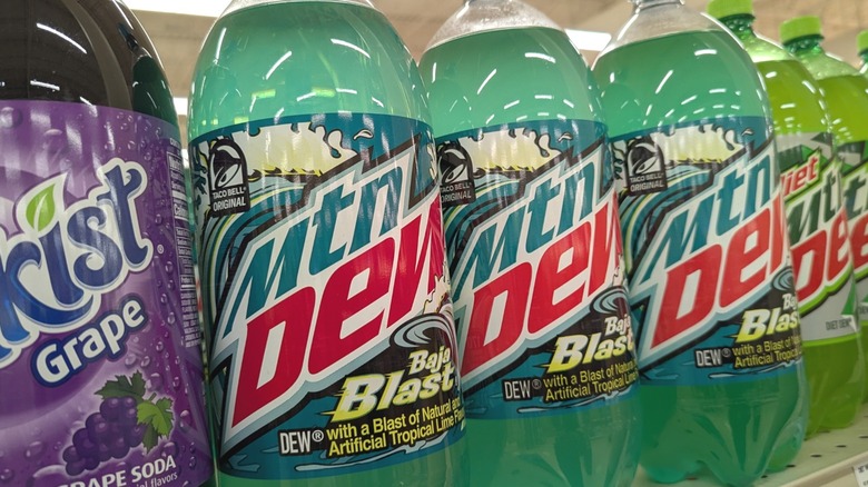 Several bottles of Mountain Dew on a supermarket shelf.