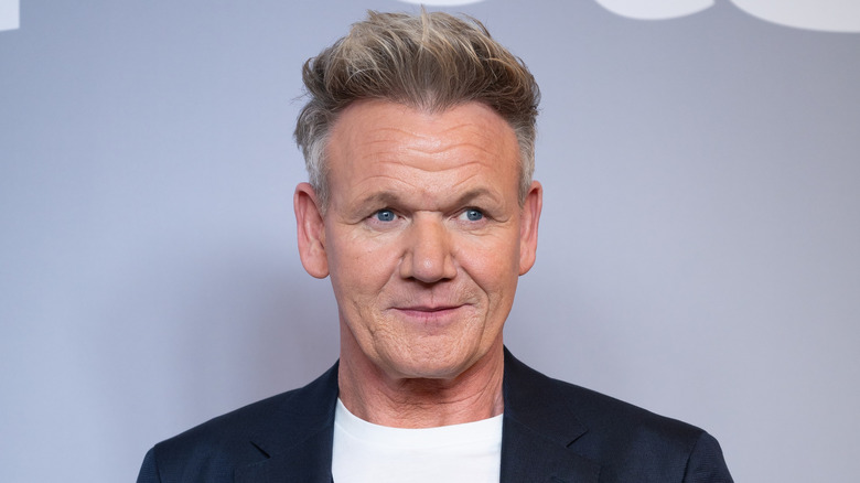 Gordon Ramsay wearing a suit jacket and t-shirt on the red carpet.