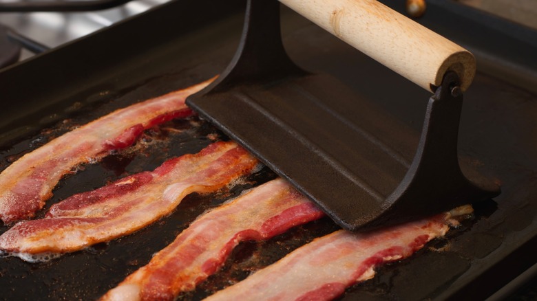 Bacon on griddle with press on top