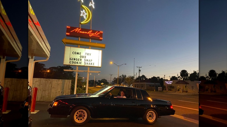 Car parked outside drive-in diner at night