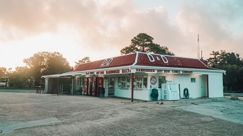 Exterior of D&D Drive In and parking lot in front of sunset