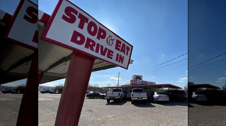 Stop and eat drive in sign in front of parking lot and restaurant