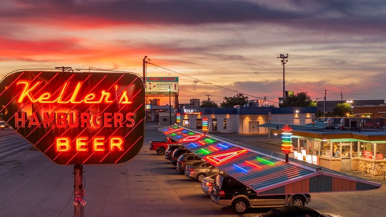 Night photo of Keller's exterior parking lot with cars and neon sign.
