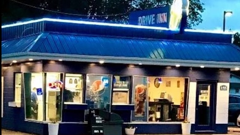 Exterior of Mels Drive Inn with blue roof and neon ice cream cone sign.