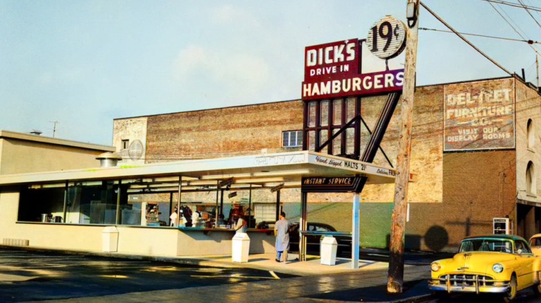 Dick's Hamburgers Drive In exterior with sign and yellow vintage car