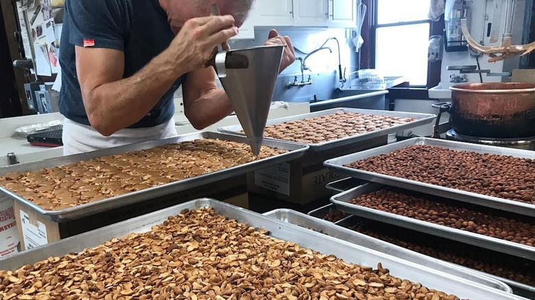 Chef prepares chocolate-covered nut candies at Sweenor's Chocolates