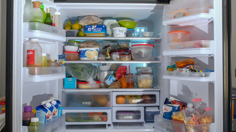 The French doors of a refrigerator are opened to reveal its contents