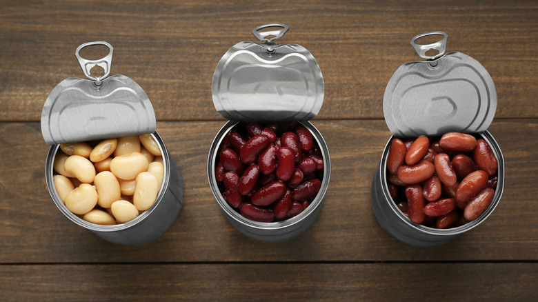 Three kinds of canned beans with the lids open