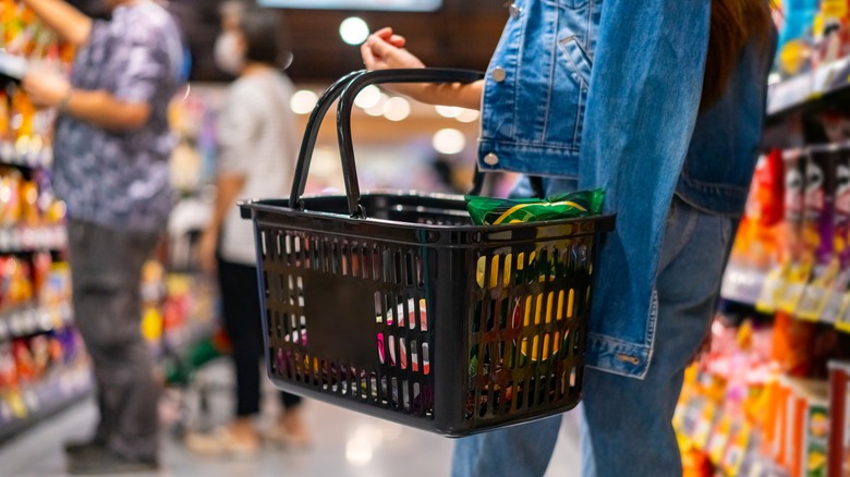 Person grocery shopping with items in basket