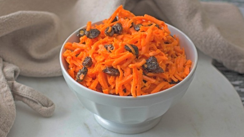 A bowl of carrot raisin salad.