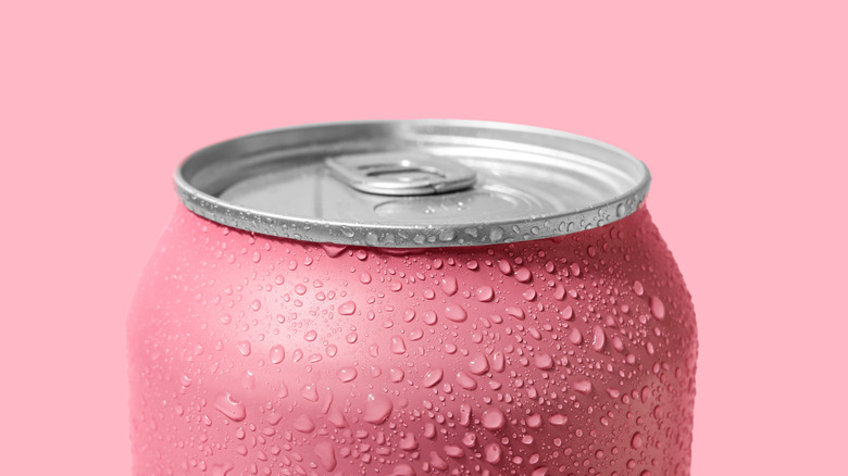 A closeup of a pink soda can with water droplets clinging to it