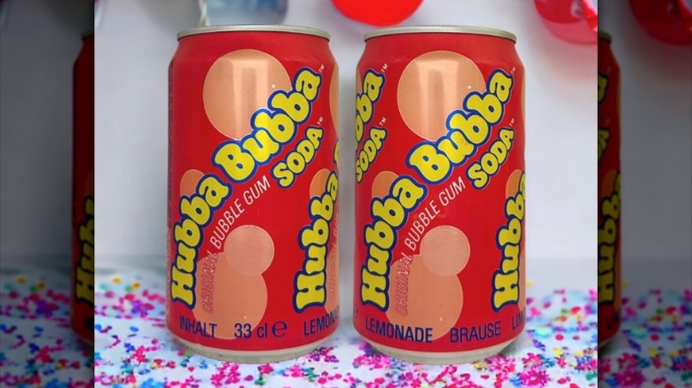 Two pinkish-red and yellow cans of Hubba Bubba soda side by side