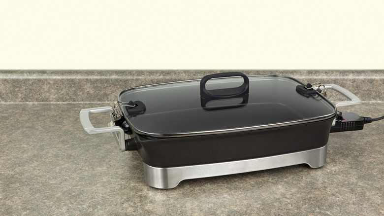 Electric skillet with lid on counter