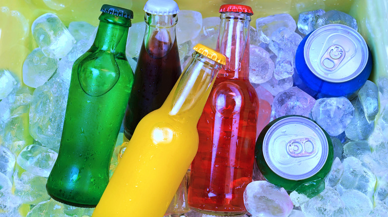 Glass bottles and cans of soda on ice