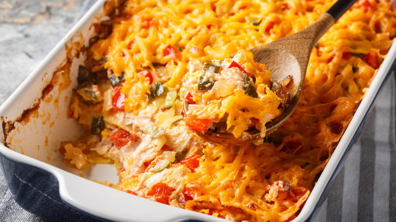 Spoon scooping out serving of King Ranch casserole from baking dish