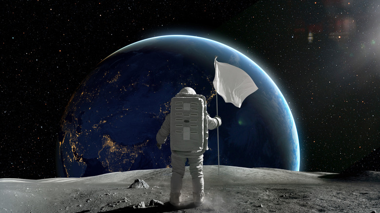 An astronaut holding a white flag on the moon while gazing at the Earth