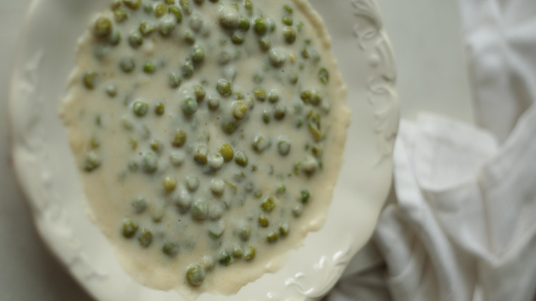 creamed peas in a white bowl