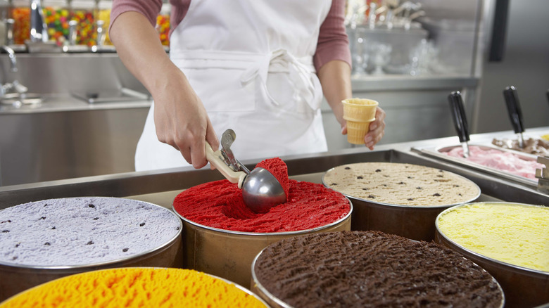 Woman scooping ice cream inside shop