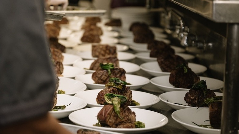 rows of plated steaks at St. Elmo Steak House