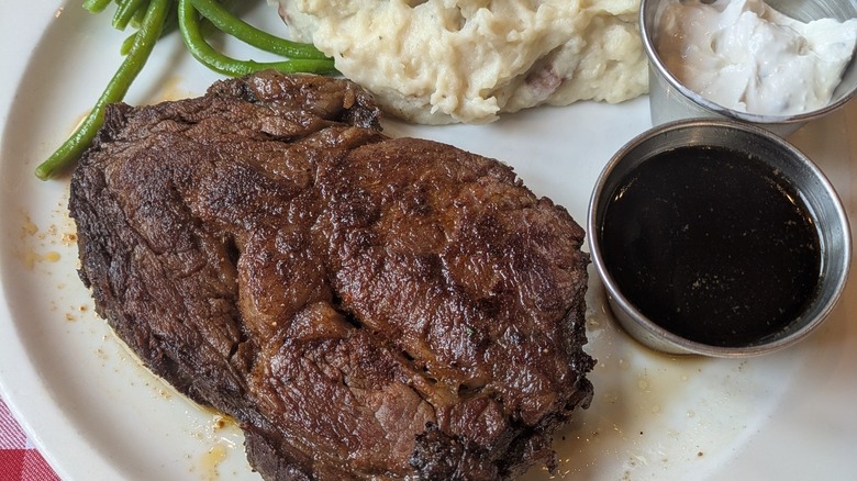 steak, potatoes, veggies on checkered tablecloth at The Buckhorn Exchange