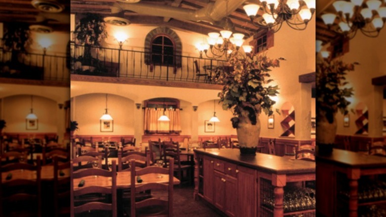 A wide shot view of the interior of an Olive Garden restaurant from many years ago with rustic Italian decor.