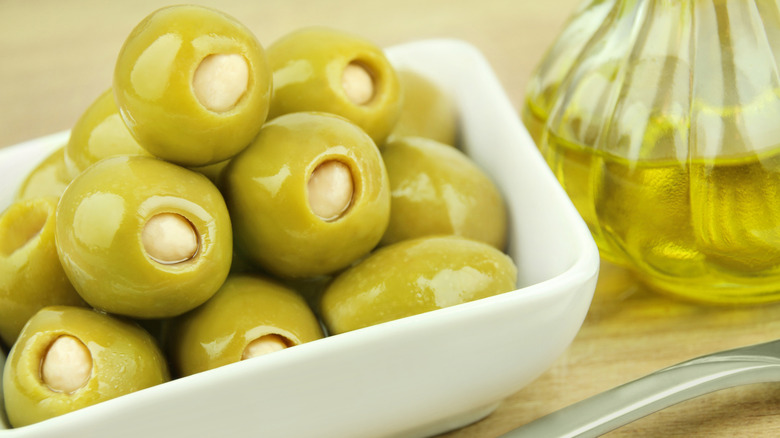 Garlic-stuffed olives with olive oil in the background