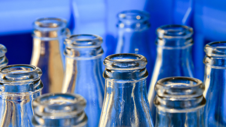Closeup of empty glass soda bottles in a blue container