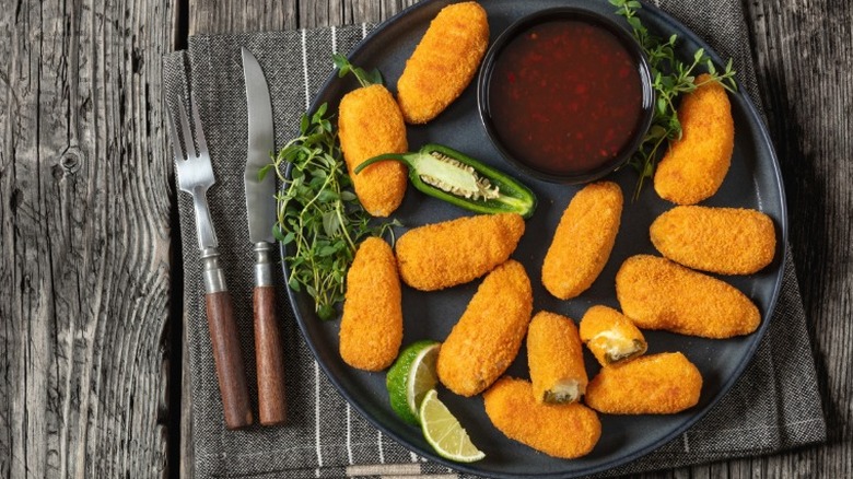 Jalapeño poppers on a black plate.