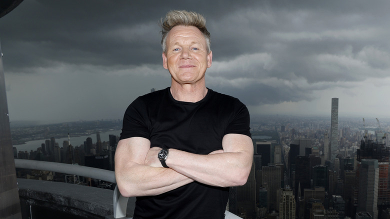 Gordon Ramsay crosses his hands and smiles for the camera during his visit to the Empire State Building at the Empire State Building on June 14, 2023 in New York City.
