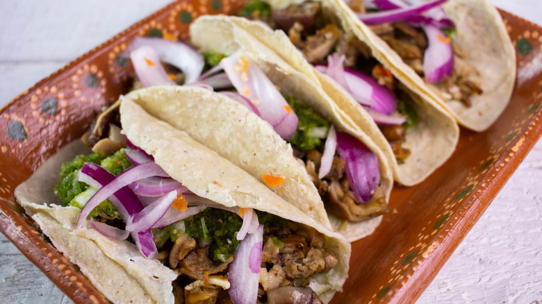 Carnitas tacos on a brown patterned tray