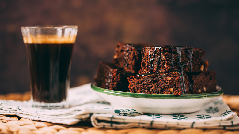 A plate of brownies and a cup of espresso on a table