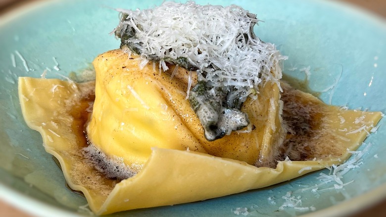 Egg yolk ravioli with brown butter sauce and shredded cheese