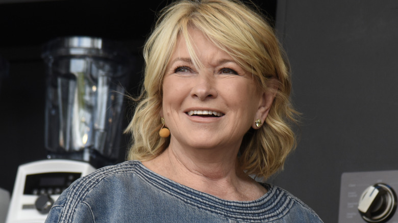 Martha Stewart smiles in a gray blouse at a cooking demonstration