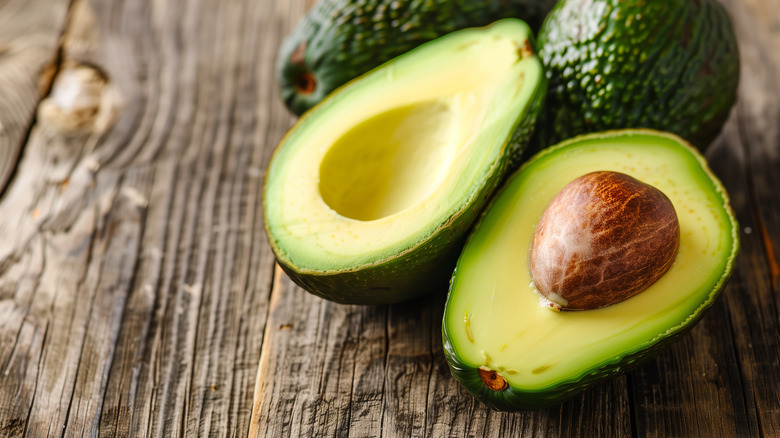 Sliced avocados sitting on a wooden surface