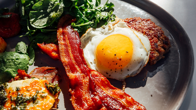 An American style breakfast with greens, bacon, egg, sausage, and more!