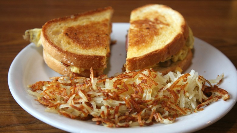 Hash browns on a plate with a sandwich.