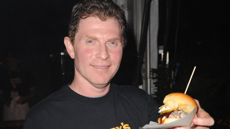 Bobby Flay holding up a burger