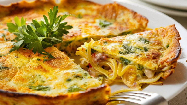 Frittata with pasta and parsley on round white plate
