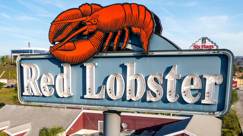 Red Lobster road sign with a large red lobster on top of a blue and white marquee