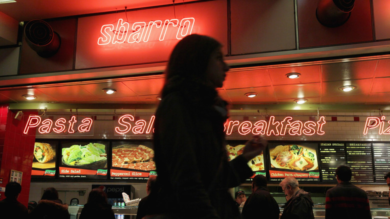 silhouette in front of a Sbarro in a mall