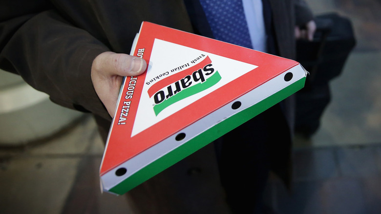 hand holding Sbarro pizza slice box